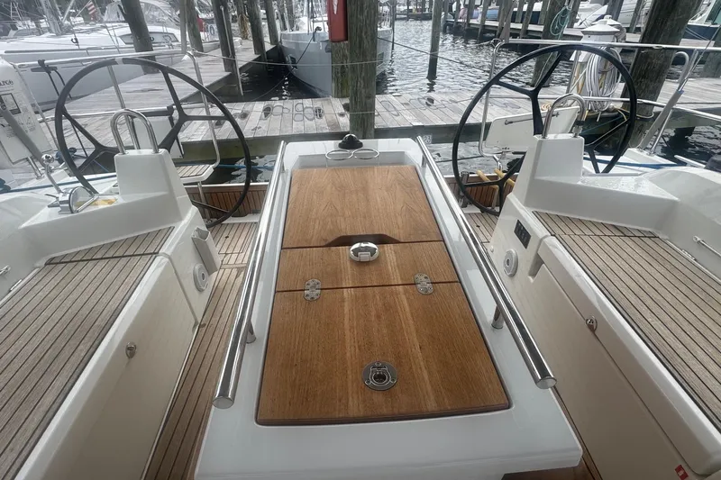 Bluebird Yacht Photos Pics Cockpit of 2022 Beneteau Oceanis 40.1 sailboat with dual steering wheels and wooden table.
