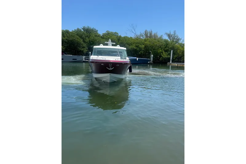  Yacht Photos Pics 2020 Formula 430 Super Sport Crossover boat cruising on calm water near a dock.