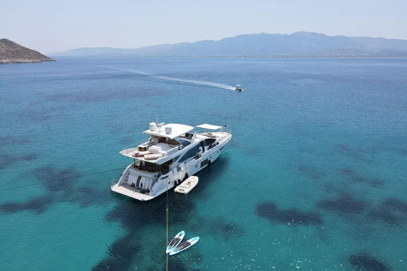  Yacht Photos Pics Luxurious 2015 Azimut 80 yacht anchored in clear blue waters, with scenic mountain backdrop.