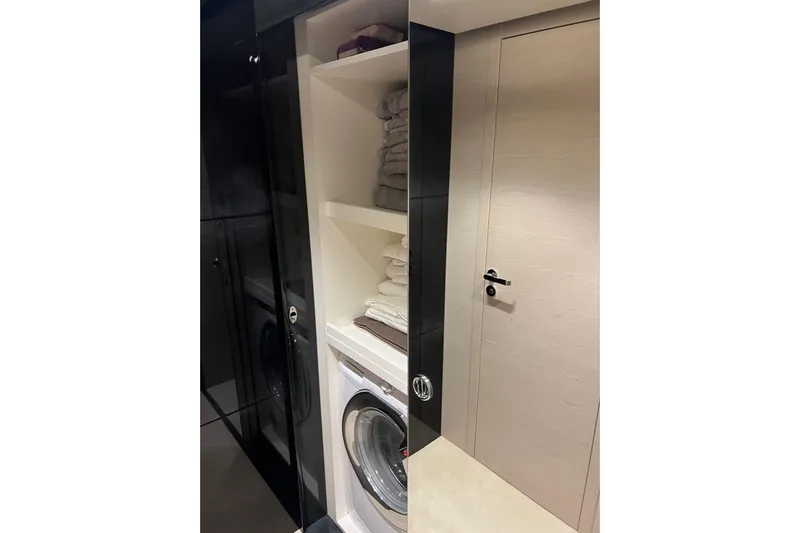  Yacht Photos Pics Laundry area with washer, shelves, and door on a 2015 Azimut 80 yacht.