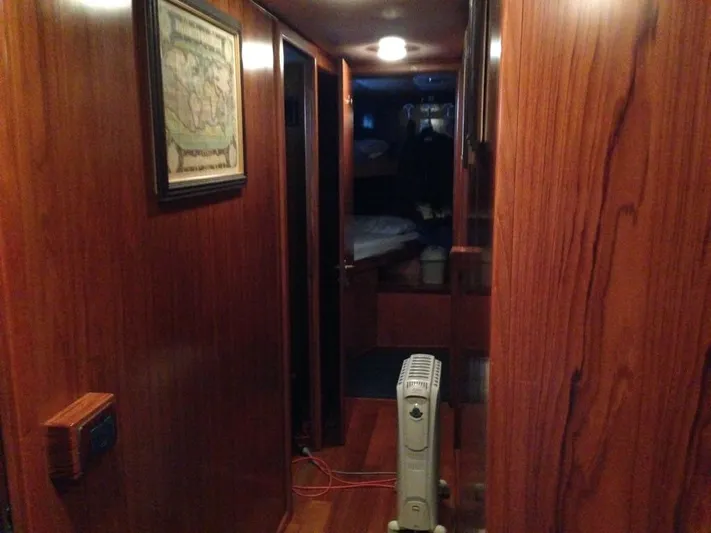  Yacht Photos Pics Wood-paneled hallway inside 2005 Cantieri Nord Est Navalmeccanica Navetta yacht, featuring a heater and framed artwork.
