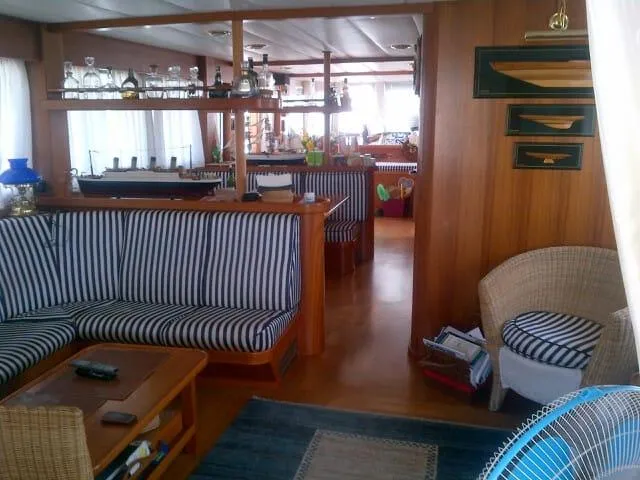  Yacht Photos Pics Luxurious interior of 2005 Cantieri Nord Est Navalmeccanica Navetta yacht with striped seating and wooden decor.