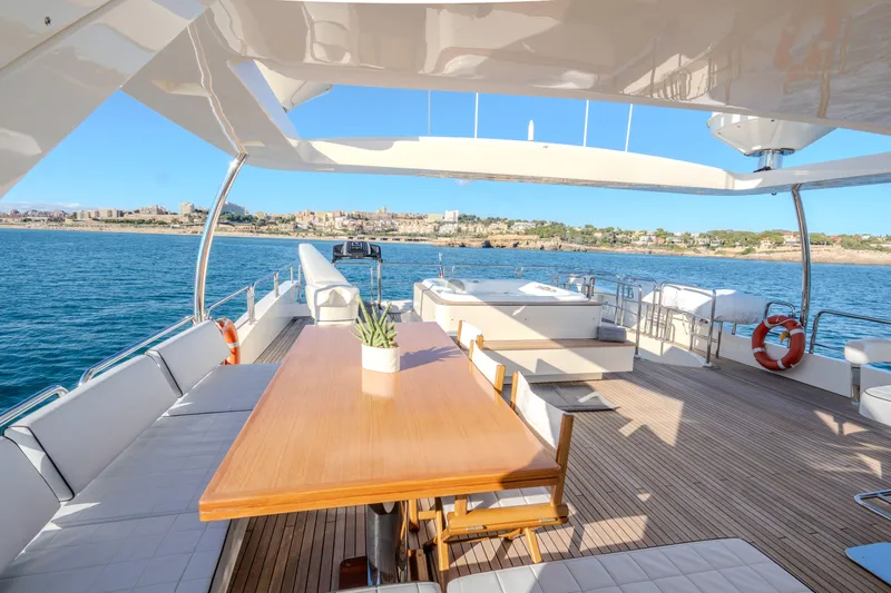 Yacht Photos Pics Luxurious 2013 Azimut 105 yacht deck with dining area, overlooking serene ocean and coastal view.