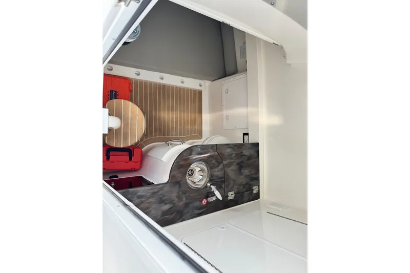  Yacht Photos Pics 2022 Regulator 34 interior storage compartment with equipment and wooden flooring.