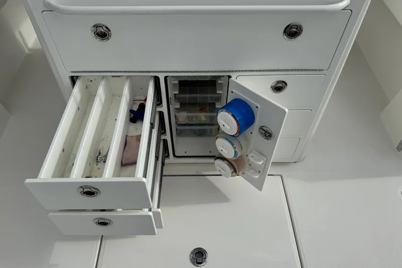  Yacht Photos Pics 2022 Regulator 34 boat storage compartments with open drawers and fishing line spools.