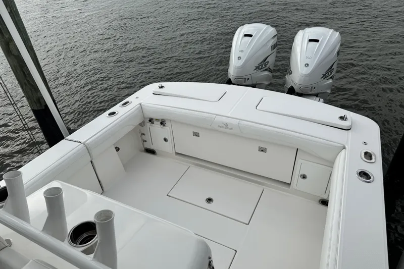  Yacht Photos Pics 2022 Regulator 34 boat with twin outboard engines, docked on calm water.