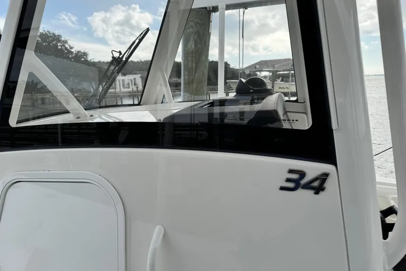  Yacht Photos Pics 2022 Regulator 34 boat, close-up of cabin and model number, docked by the water.