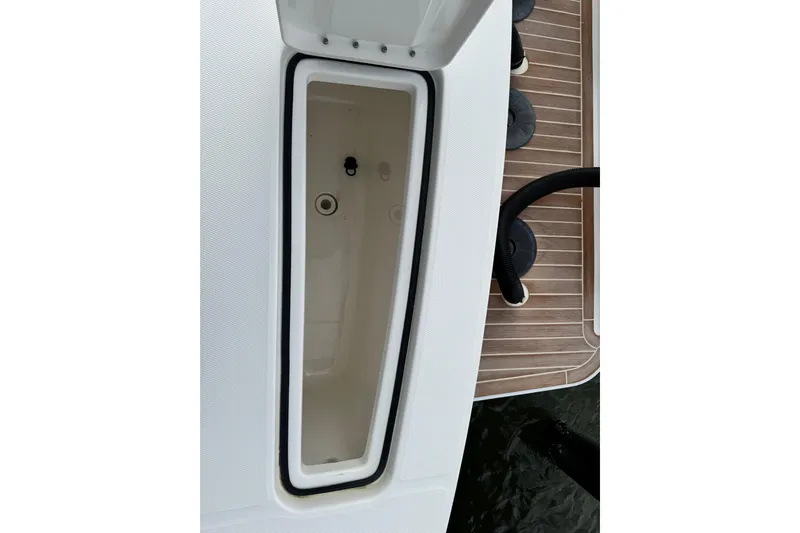  Yacht Photos Pics 2022 Regulator 34 boat storage compartment with teak deck and black hoses.