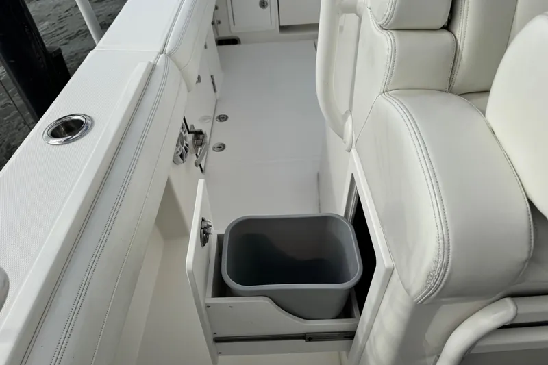  Yacht Photos Pics 2022 Regulator 34 boat interior with pull-out trash bin and cushioned seating.