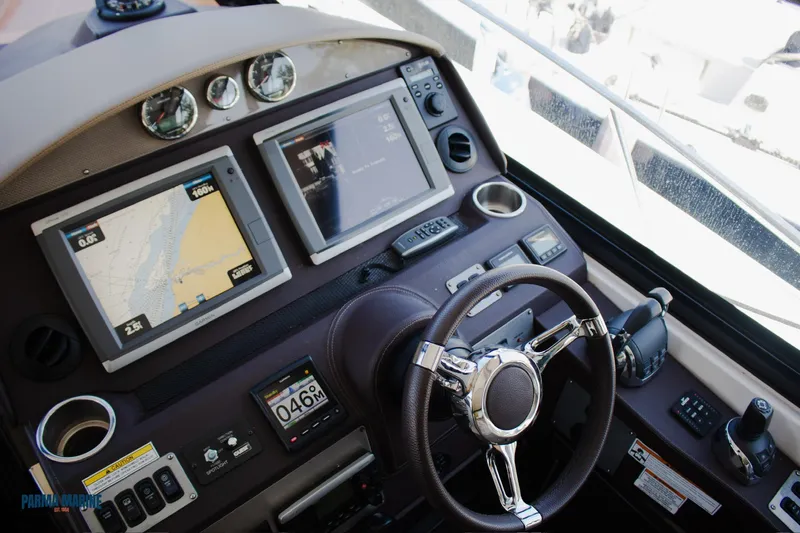 Knot On Call Yacht Photos Pics 2016 Regal 42 Sport Coupe helm with navigation screens and steering wheel.
