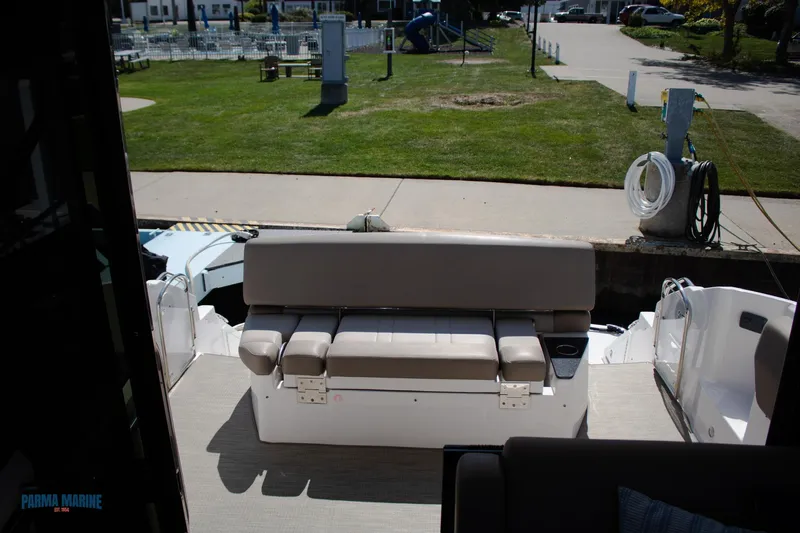 Knot On Call Yacht Photos Pics 2016 Regal 42 Sport Coupe boat interior with seating area, docked near grassy park.