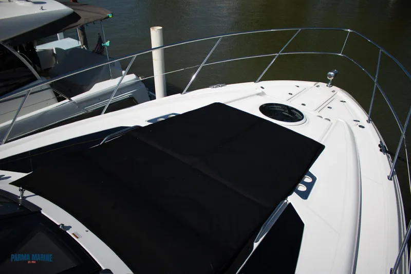 Knot On Call Yacht Photos Pics 2016 Regal 42 Sport Coupe yacht deck with black sunpad, docked on calm water.