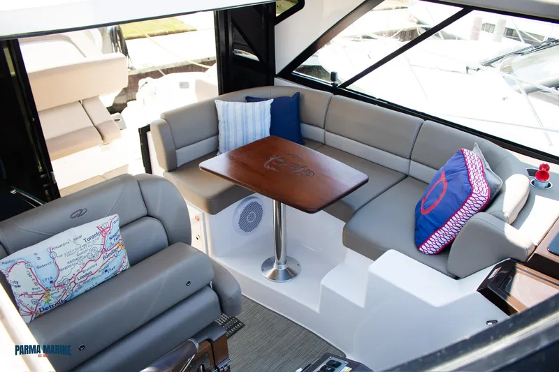 Knot On Call Yacht Photos Pics Interior of 2016 Regal 42 Sport Coupe with plush seating and wooden table.