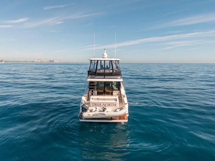 True North Yacht Photos Pics 2017 Tiara Yachts F53 Flybridge on open sea, clear sky, rear view.