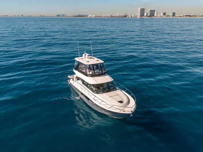 True North Yacht Photos Pics 2017 Tiara Yachts F53 Flybridge cruising on open water near a city skyline.