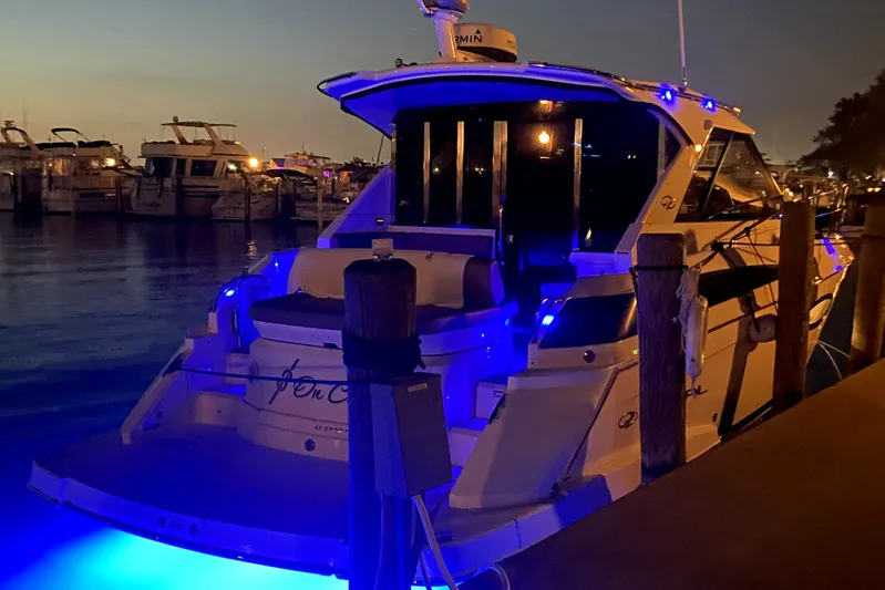 Knot On Call Yacht Photos Pics 2016 Regal 42 Sport Coupe with blue lights docked at night.