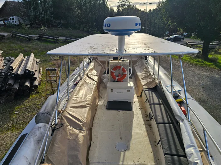 Ocean Spirit Yacht Photos Pics 1996 Eduardono RIB boat with canopy and radar, docked outdoors.