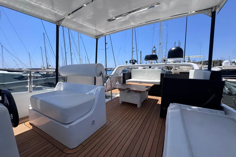  Yacht Photos Pics Spacious deck of 1998 Cantieri Lombardi 48 S yacht with seating and table.