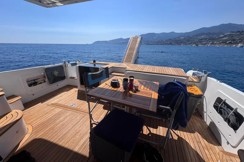  Yacht Photos Pics 1998 Cantieri Lombardi 48 S yacht deck with table, chairs, and ocean view.