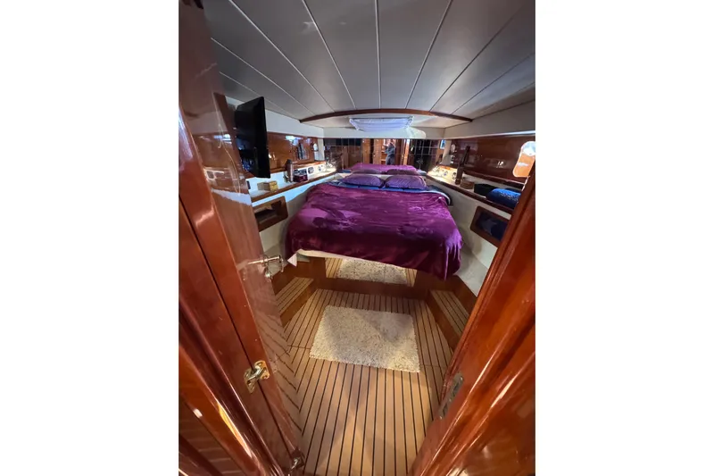  Yacht Photos Pics Luxurious 1998 Cantieri Lombardi 48 S yacht cabin with plush bedding and elegant wood finish.