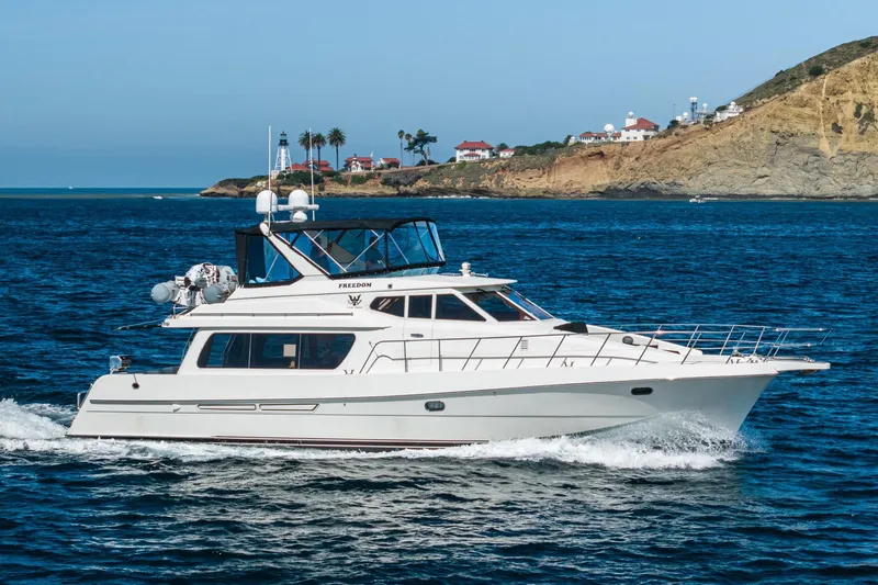 Freedom Yacht Photos Pics 2002 McKinna 57 Pilothouse yacht cruising near scenic coastal landscape.