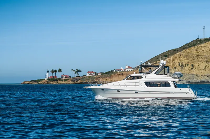 Freedom Yacht Photos Pics 2002 McKinna 57 Pilothouse yacht cruising near scenic coastal landscape.