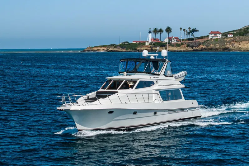 Freedom Yacht Photos Pics 2002 McKinna 57 Pilothouse yacht cruising near a scenic coastal lighthouse.
