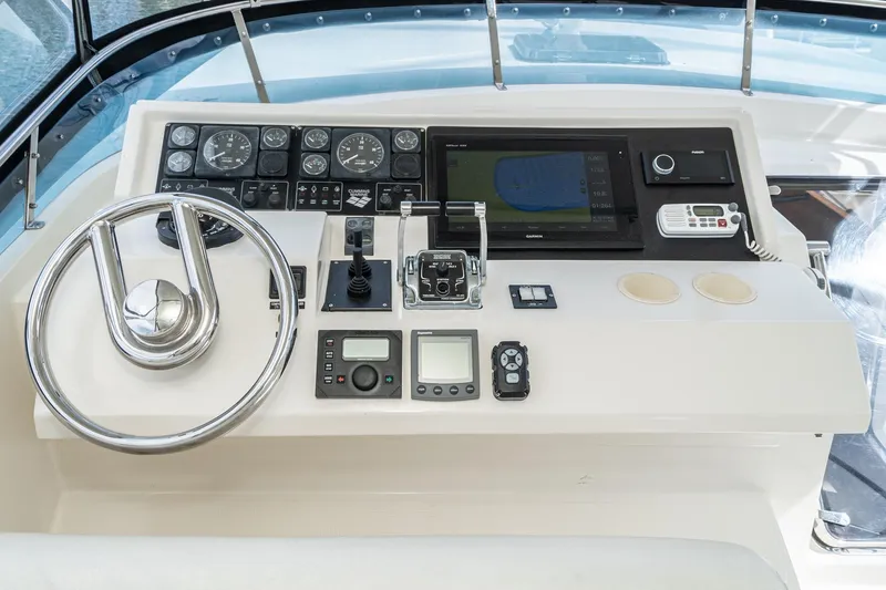Freedom Yacht Photos Pics Control panel of a 2002 McKinna 57 Pilothouse yacht with steering wheel and navigation instruments.