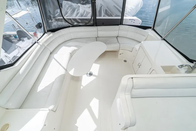 Freedom Yacht Photos Pics Luxurious interior of 2002 McKinna 57 Pilothouse yacht with white seating and table.