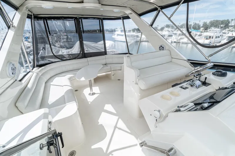 Freedom Yacht Photos Pics Luxurious 2002 McKinna 57 Pilothouse interior with white seating and helm, docked at marina.