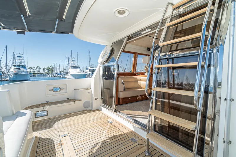 Freedom Yacht Photos Pics Luxurious 2002 McKinna 57 Pilothouse yacht interior with wooden deck and marina view.