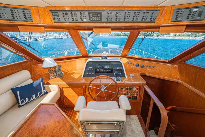 Freedom Yacht Photos Pics Pilothouse interior of 2002 McKinna 57 yacht with wooden finish and navigation controls.
