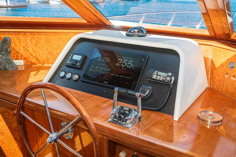 Freedom Yacht Photos Pics 2002 McKinna 57 Pilothouse helm with navigation controls and wooden steering wheel.