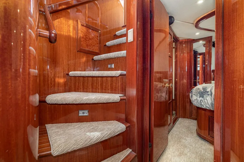 Freedom Yacht Photos Pics Luxurious interior of 2002 McKinna 57 Pilothouse yacht with polished wood and carpeted stairs.