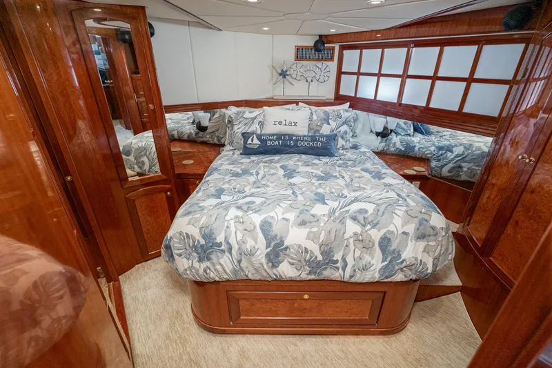 Freedom Yacht Photos Pics Luxurious 2002 McKinna 57 Pilothouse bedroom with elegant wood finish and cozy bedding.