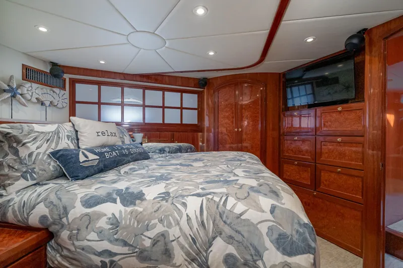 Freedom Yacht Photos Pics Luxurious 2002 McKinna 57 Pilothouse bedroom with elegant wood finishes and cozy bedding.