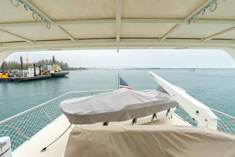 Freedom Yacht Photos Pics 2005 Offshore Yachts Pilothouse on calm waters, featuring covered deck and American flag.