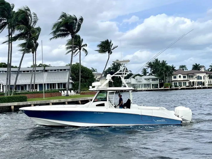 Reel Time Yacht Photos Pics 2013 Boston Whaler 370 Outrage boat cruising near waterfront homes.