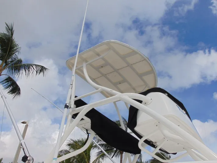Reel Time Yacht Photos Pics Boston Whaler 370 Outrage 2013 boat tower against a cloudy sky with palm trees.