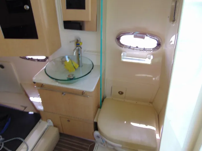 Reel Time Yacht Photos Pics Interior of 2013 Boston Whaler 370 Outrage boat, featuring a compact bathroom with sink and toilet.