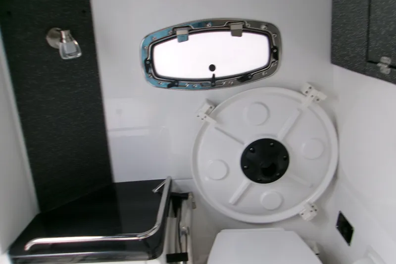  Yacht Photos Pics Interior of 2026 Monterey Elite 30 OB boat, featuring a compact cabin with a porthole.