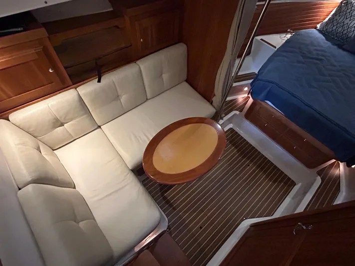  Yacht Photos Pics Interior of 2015 Back Cove 34 yacht with beige sofa, wooden table, and bed.