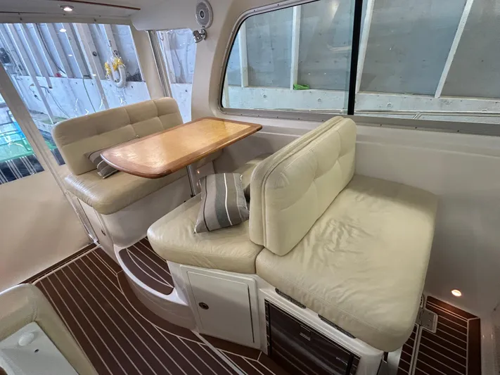  Yacht Photos Pics Interior of 2015 Back Cove 34 boat with cushioned seating and wooden table.