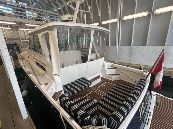  Yacht Photos Pics 2015 Back Cove 34 boat in dock, featuring striped seating and a Canadian flag.