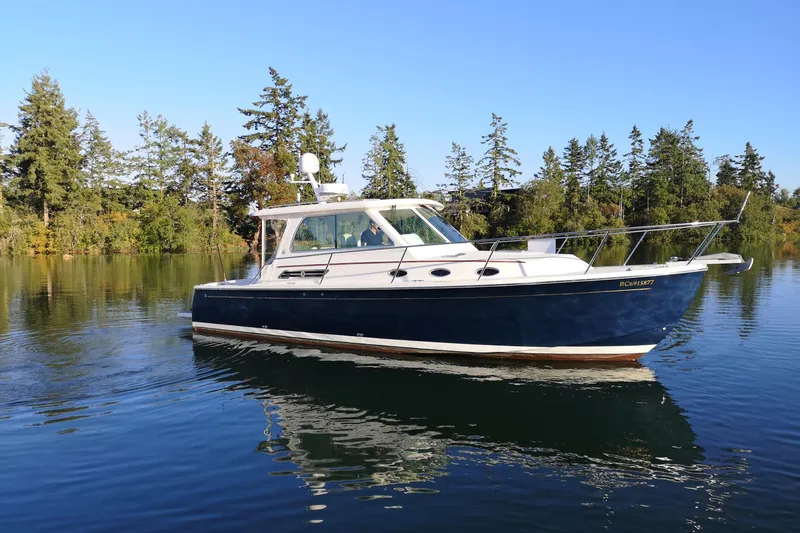  Yacht Photos Pics 2015 Back Cove 34 boat on calm water with trees in the background.