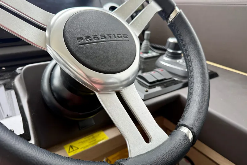Freiheit Yacht Photos Pics Steering wheel of a 2020 Prestige 590 yacht, featuring sleek design and controls.
