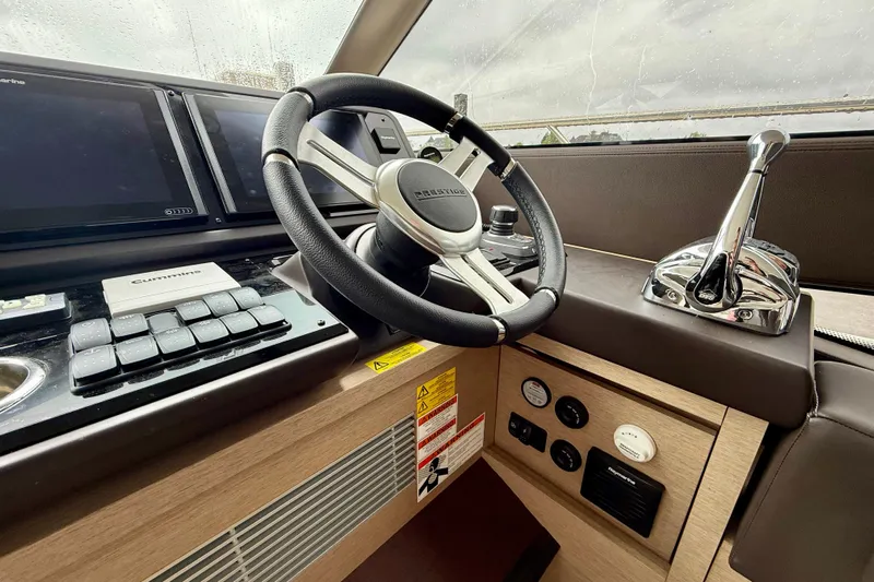 Freiheit Yacht Photos Pics Control panel of a 2020 Prestige 590 yacht with steering wheel and navigation equipment.