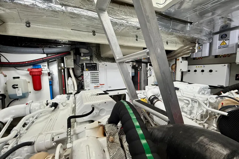 Freiheit Yacht Photos Pics Engine room of a 2020 Prestige 590 yacht, featuring mechanical components and a ladder.