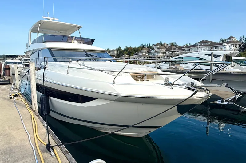 Freiheit Yacht Photos Pics Luxury 2020 Prestige 590 yacht docked at marina, clear blue sky background.