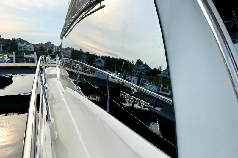 Freiheit Yacht Photos Pics 2020 Prestige 590 yacht docked, reflecting waterfront homes and serene sunset.